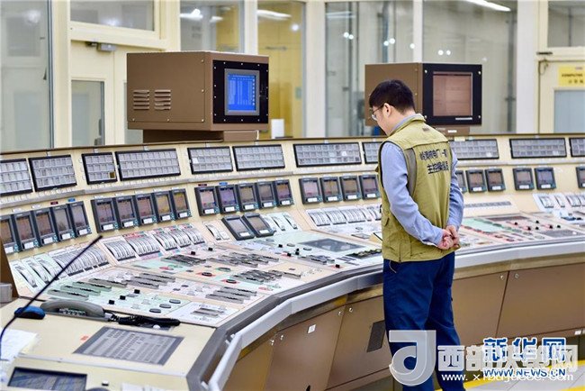4月12日,工作人员在岭澳核电站1号机组主控室监看机组运行情况.