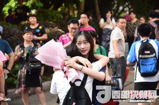 资料图：一名家属拥抱走出考场的考生。 王以照 摄