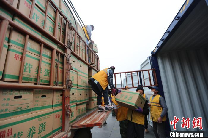 图为铁路装卸作业人员正在将云南特色农产品装入集装箱。　杨航 摄