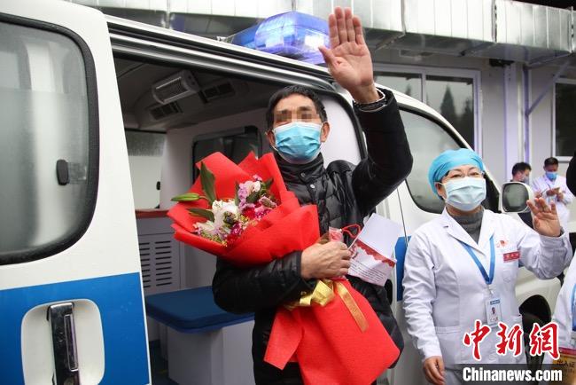 图为贵州省最后一名新冠肺炎确诊患者从贵州省将军山医院出院，患者与众人挥手告别。　瞿宏伦 摄