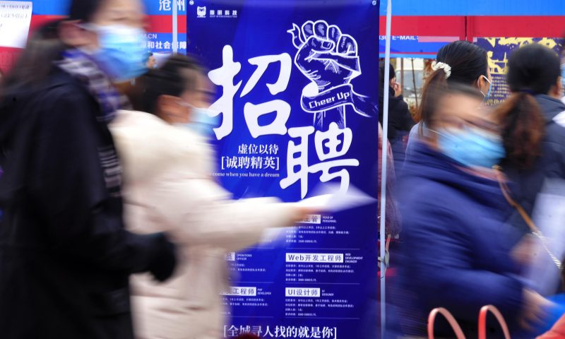 求职者从一家招聘企业的广告牌前走过。新华社发（苑立伟 摄）