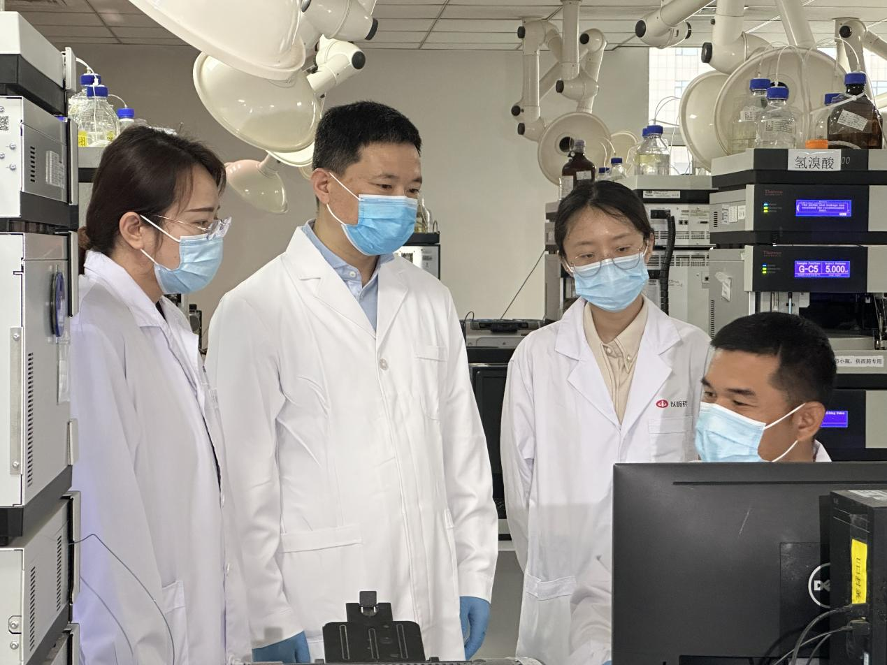 贾振华(左二)与科研人员在讨论业务。 孙阳阳摄